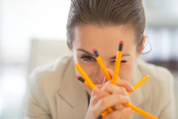 Mujer de negocios sosteniendo lápices — Foto de Stock