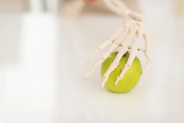 Människans skelett hand innehav apple — Stockfoto