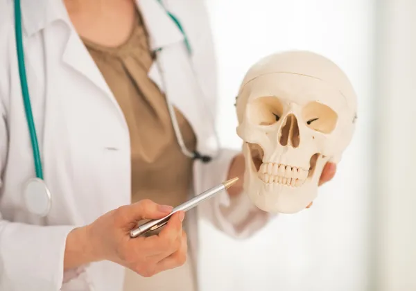 Doctora mujer mostrando cráneo humano — Foto de Stock