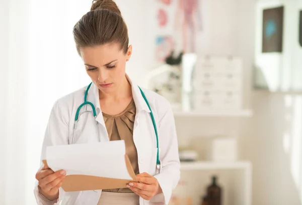 Doctor mirando en portapapeles — Foto de Stock