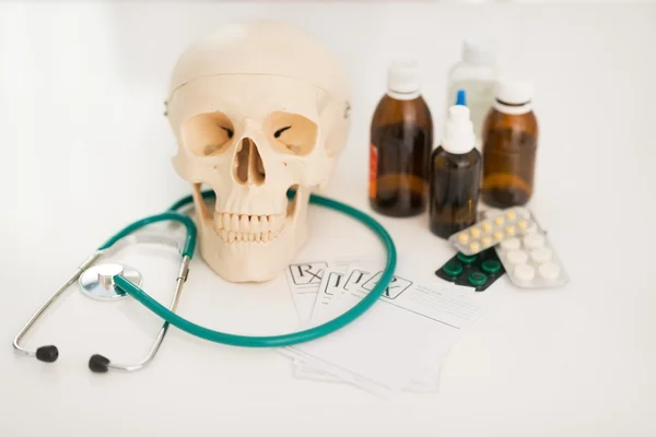 Human skull stethoscope and drugs — Stock Photo, Image