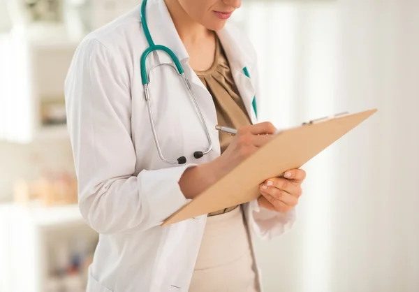 Kobieta lekarz pismo w schowku — Zdjęcie stockowe