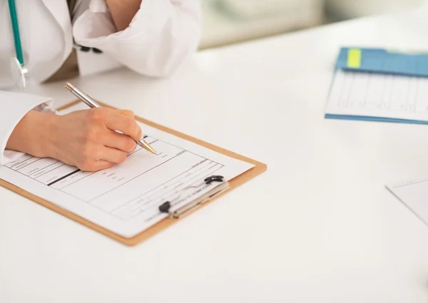 Médico mulher escrevendo na área de transferência — Fotografia de Stock