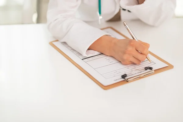 Médico médico mujer escribiendo en portapapeles —  Fotos de Stock