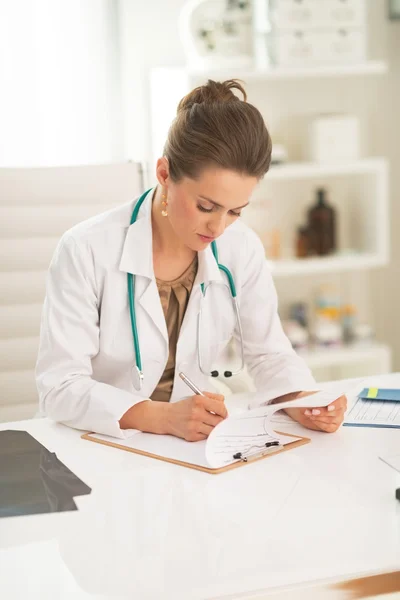 Kobieta lekarz pismo w schowku — Zdjęcie stockowe