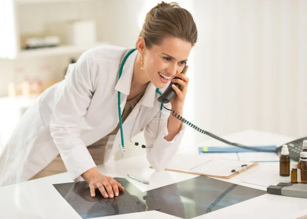 Doctor with fluorography talking phone — Stock Photo, Image