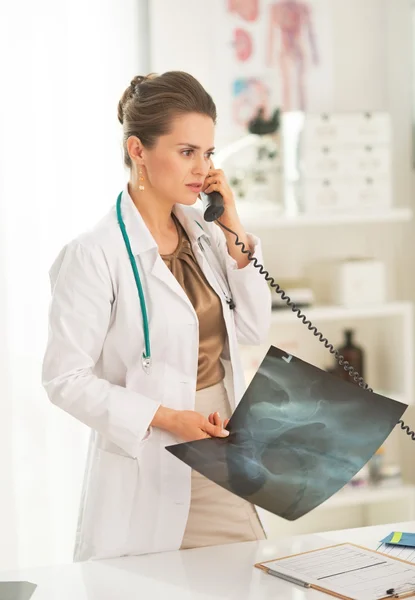 Doctor with fluorography talking phone — Stock Photo, Image