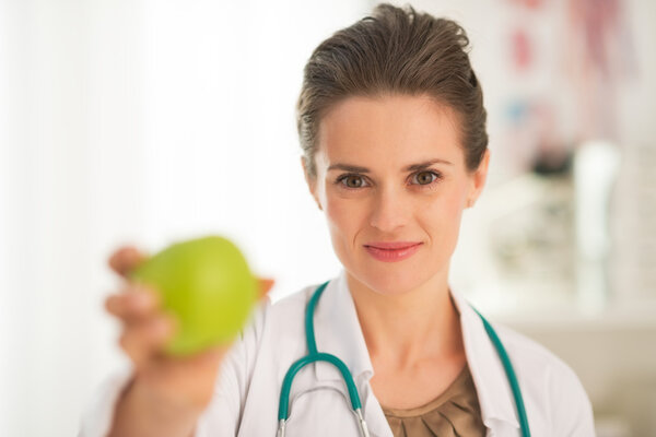 Врач женщина дает яблоко
