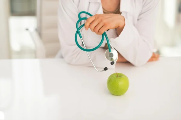 Zbliżenie na kobieta lekarz stetoskop i jabłko — Zdjęcie stockowe