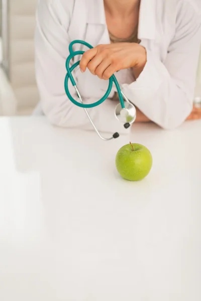 Primer plano de la mujer médica con estetoscopio y manzana —  Fotos de Stock