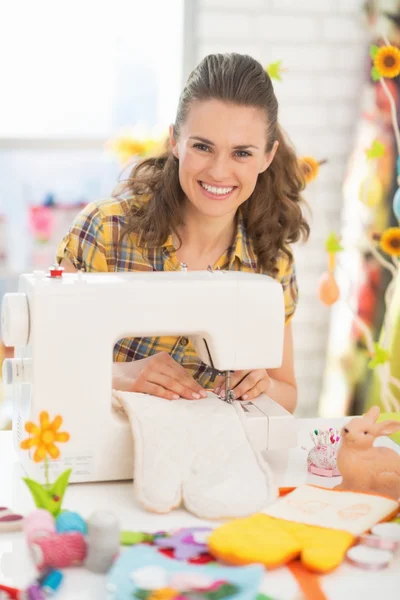 Happy young woman making easter pot holder mitts — Stock Photo, Image