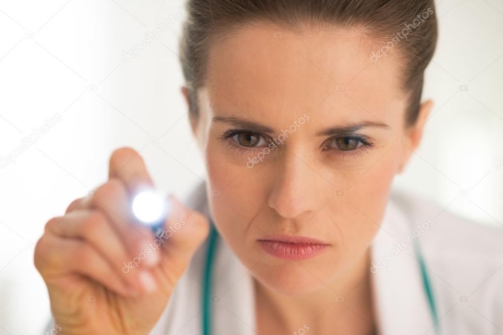 Doctor woman examining using flashlight
