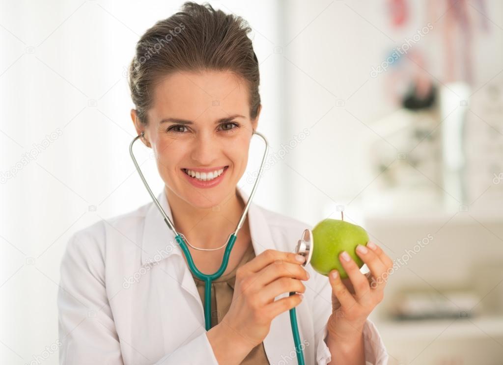 Doctor examining apple with stethoscope