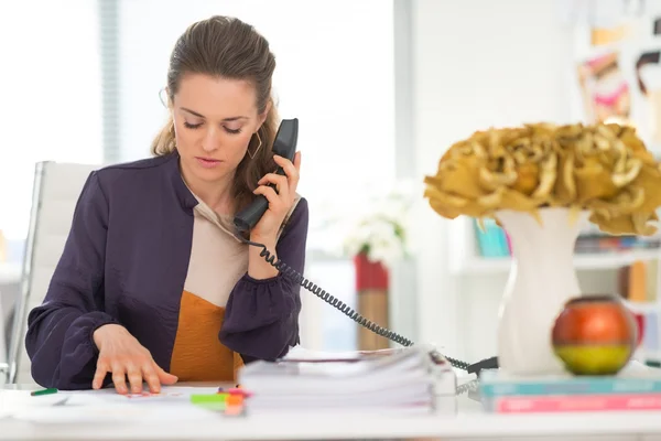 Fashion designer talking phone in office — Stock Photo, Image