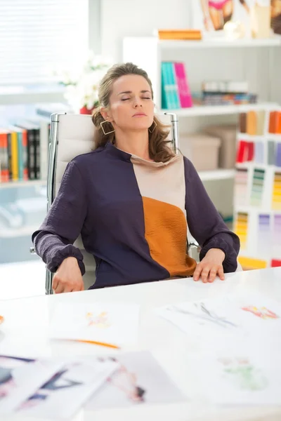 Tired fashion designer sitting in office — Stock Photo, Image