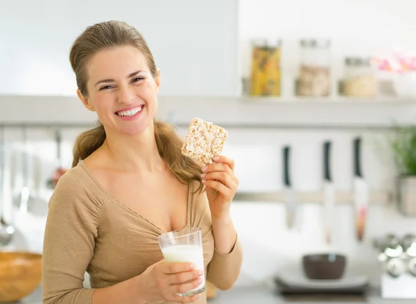 Mujer comiendo bocadillos en la cocina — Foto de Stock