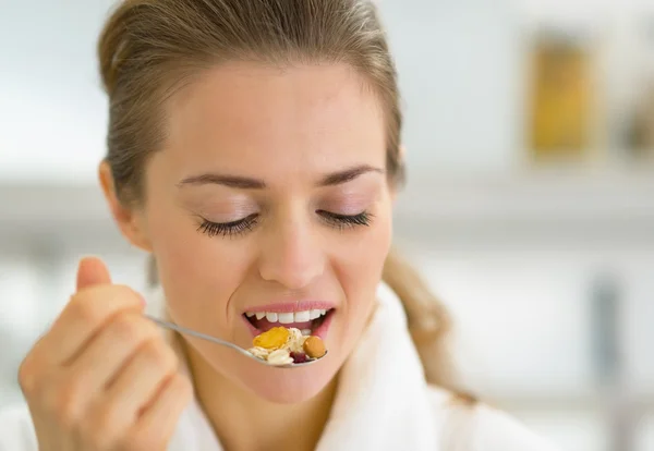 Young woman eating muesli in kitchen — Stock Photo, Image