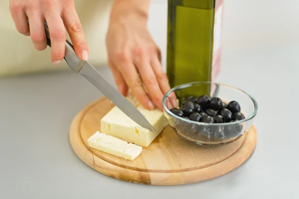 Joven ama de casa cortar queso — Foto de Stock