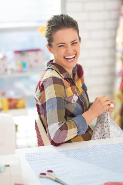 Costureira rindo costura em estúdio — Fotografia de Stock