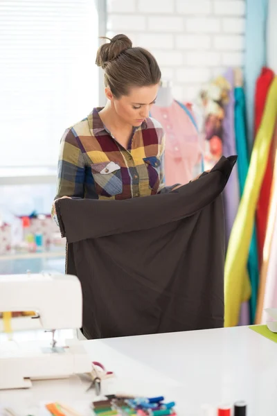 Seamstress looking on fabric in studio — Stock Photo, Image