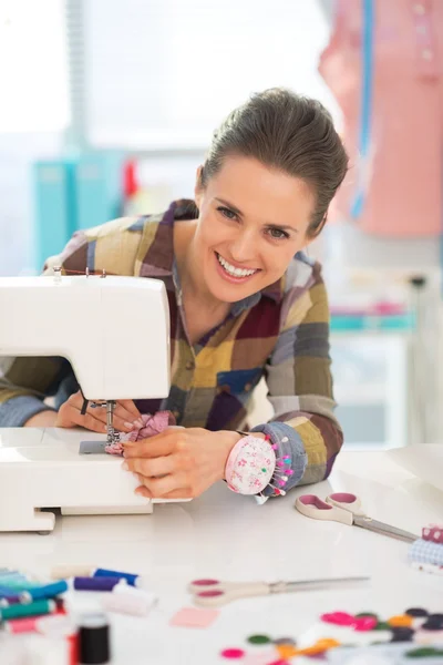Happy seamstress sewing in studio — Stock Photo, Image
