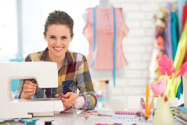 Happy seamstress sewing in studio — Stock Photo, Image