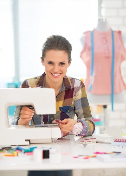 Smiling seamstress sewing in studio — Stock Photo, Image