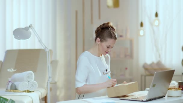Tersenyum Setengah Baya Karyawan Wanita Dengan Laptop Dan Bingkisan Studio — Stok Video