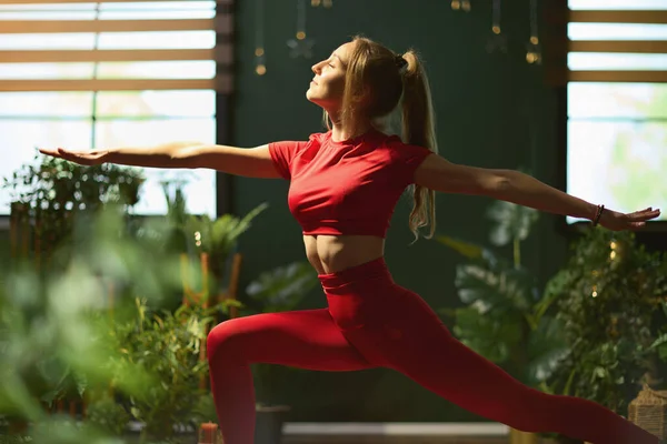 Young Woman Red Fitness Clothes Modern Green Home Doing Yoga — Φωτογραφία Αρχείου