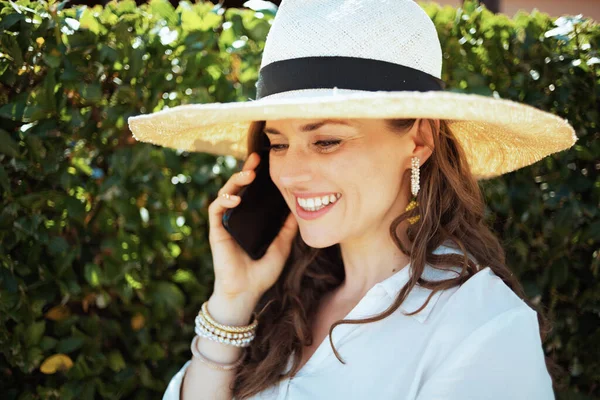 Счастливая Стильная Летняя Домохозяйка Белой Рубашке Шляпе Говорящая Смартфону Улице — стоковое фото