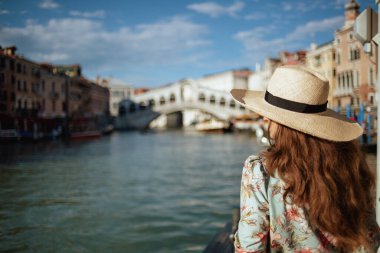 İtalya, Venedik 'te Rialto Köprüsü yakınlarında çiçek desenli elbisesiyle gezen şık bir kadının arkasında görülmüş..