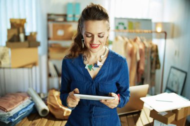 Gülümseyen şık orta yaşlı küçük işletme sahibi ofiste tableti olan bir kadın..