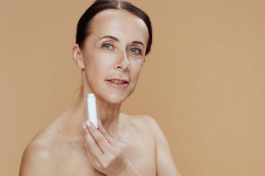 modern woman with hygienic lipstick on beige background.