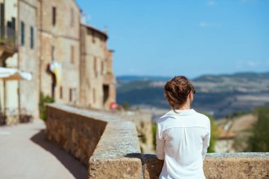 İtalya 'ya git. Tuscany, İtalya 'da Pienza' da son moda yalnız gezgin bir kadının arkasından görüldü..