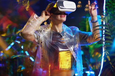 Gülümseyen stil sahibi kadın VR gözlükleriyle keşif yapıyor..