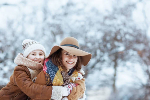 Smiling Modern Mother Child Hats Sheepskin Coats Mittens Embracing City — Stock Photo, Image