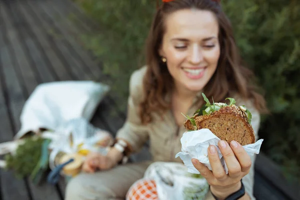 Closeup Happy Middle Aged Woman Tote Bag Sandwich Sitting Outdoors — Stock Photo, Image