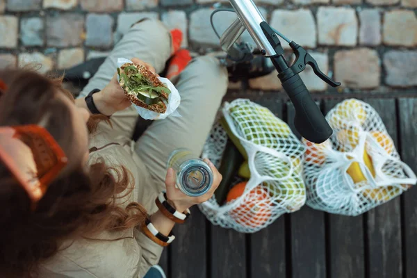 Şehrin Dışında Otururken Ipe Bağlı Çanta Scooter Şişesi Sandviç Yiyen — Stok fotoğraf