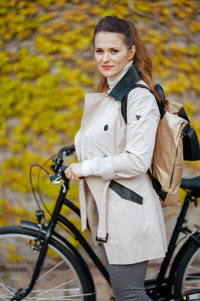 Элегантная Женщина Бежевом Плаще Велосипедом Рюкзаком Зеленой Стены Улице Города — стоковое фото