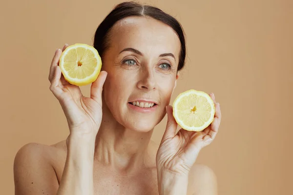 Portrait Modern Middle Aged Woman Lemon Isolated Beige Background — Stock fotografie