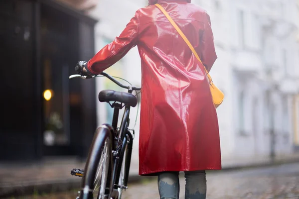 Сзади Женщина Красном Дождевике Велосипедом Идущим Дождем Городе — стоковое фото