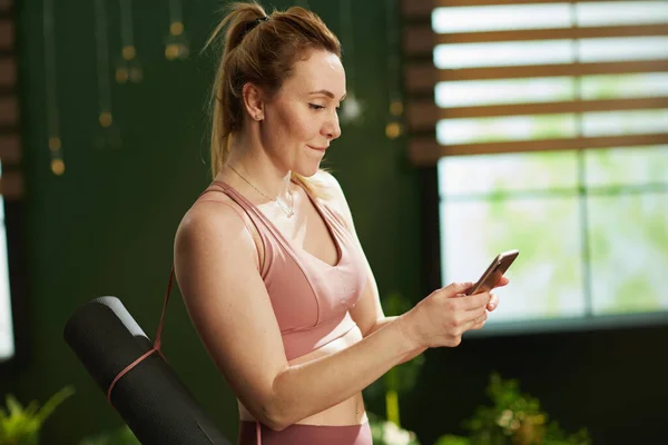 Modern Middle Aged Woman Yoga Mat Using Smartphone Modern Green — стоковое фото