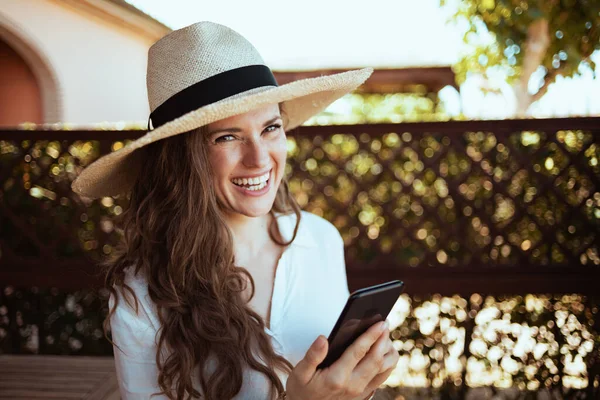 Portrait Smiling Elegant Woman White Shirt Hat Using Smartphone App — Stockfoto