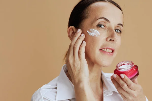 Happy Modern Woman Facial Cream Jar White Shirt Beige Background — Stockfoto