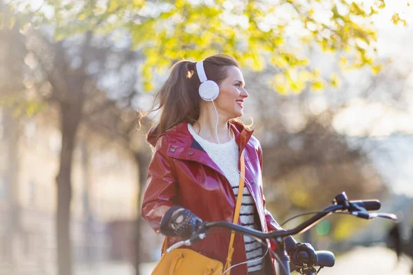 Mulher Moderna Sorridente Capa Chuva Vermelha Com Bicicleta Ouvindo Música — Fotografia de Stock