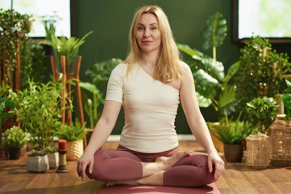 modern woman at modern green home meditating.