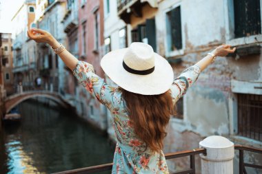 Venedik, İtalya 'da çiçek desenli şapkalı genç bir turist kadın gördüm..