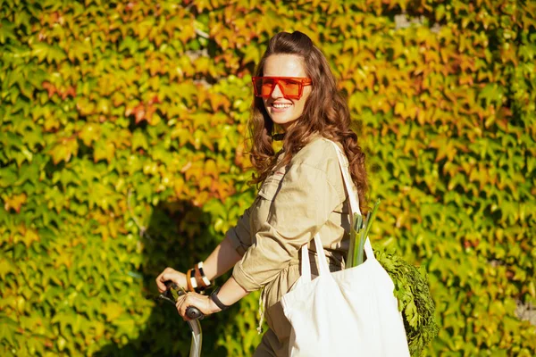 Счастливая Сорокалетняя Женщина Солнцезащитных Очках Сумкой Скутером Фоне Зеленых Стен — стоковое фото