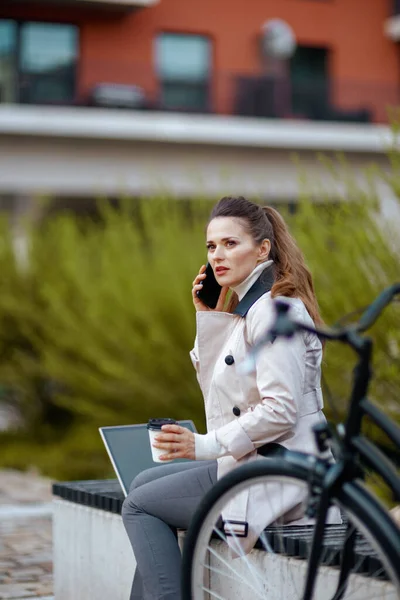 Zamyšlená Moderní Žena Béžovém Plášti Bicyklem Šálkem Horkého Kakaa Notebookem — Stock fotografie