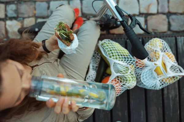 Şehrin Dışında Otururken Ipe Bağlı Çanta Scooter Şişesi Sandviç Yiyen — Stok fotoğraf